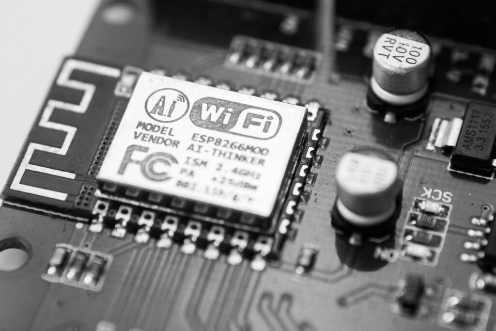 Close-up of a circuit board featuring an ESP8266MOD Wi-Fi module labelled "AI-Thinker," surrounded by telecoms electronics manufacturing components.