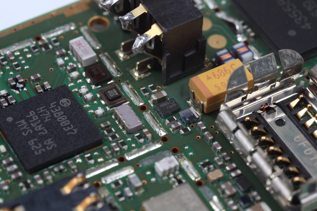 Close-up view of an electronic circuit board showcasing various components, including microchips, resistors, capacitors, and connectors—key elements in energy electronics manufacturing.