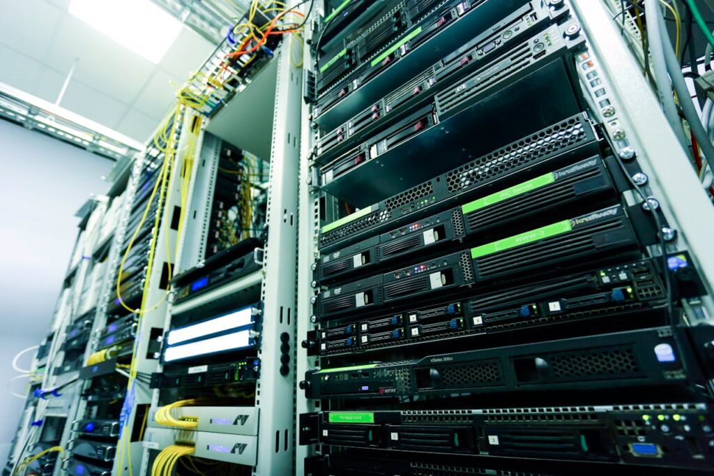 A close-up view of several server racks with network cables and electronic equipment in a data centre highlights the precision of electronics manufacturing.